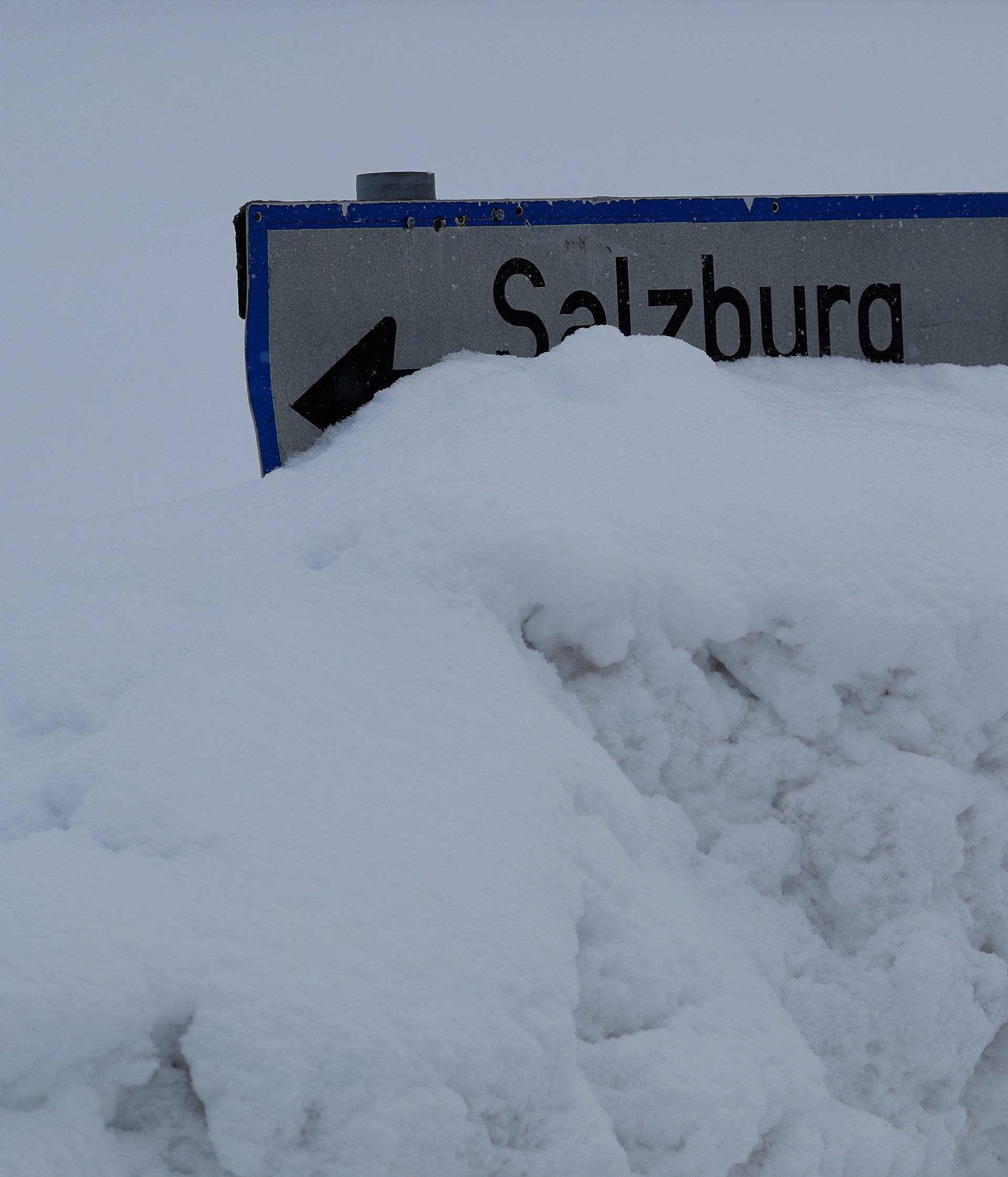 A street sign is covered in snow on an icy road in Knoppen