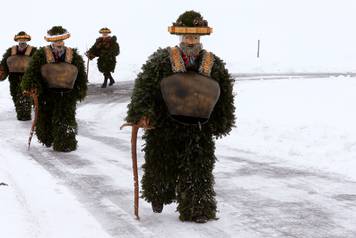 Men dressed as "Chlaeuse" walk during the traditional "Sylvesterchlausen" near Urnaesch