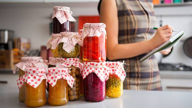 Closeup of preserved vegetables in glass jars on kitchen counter