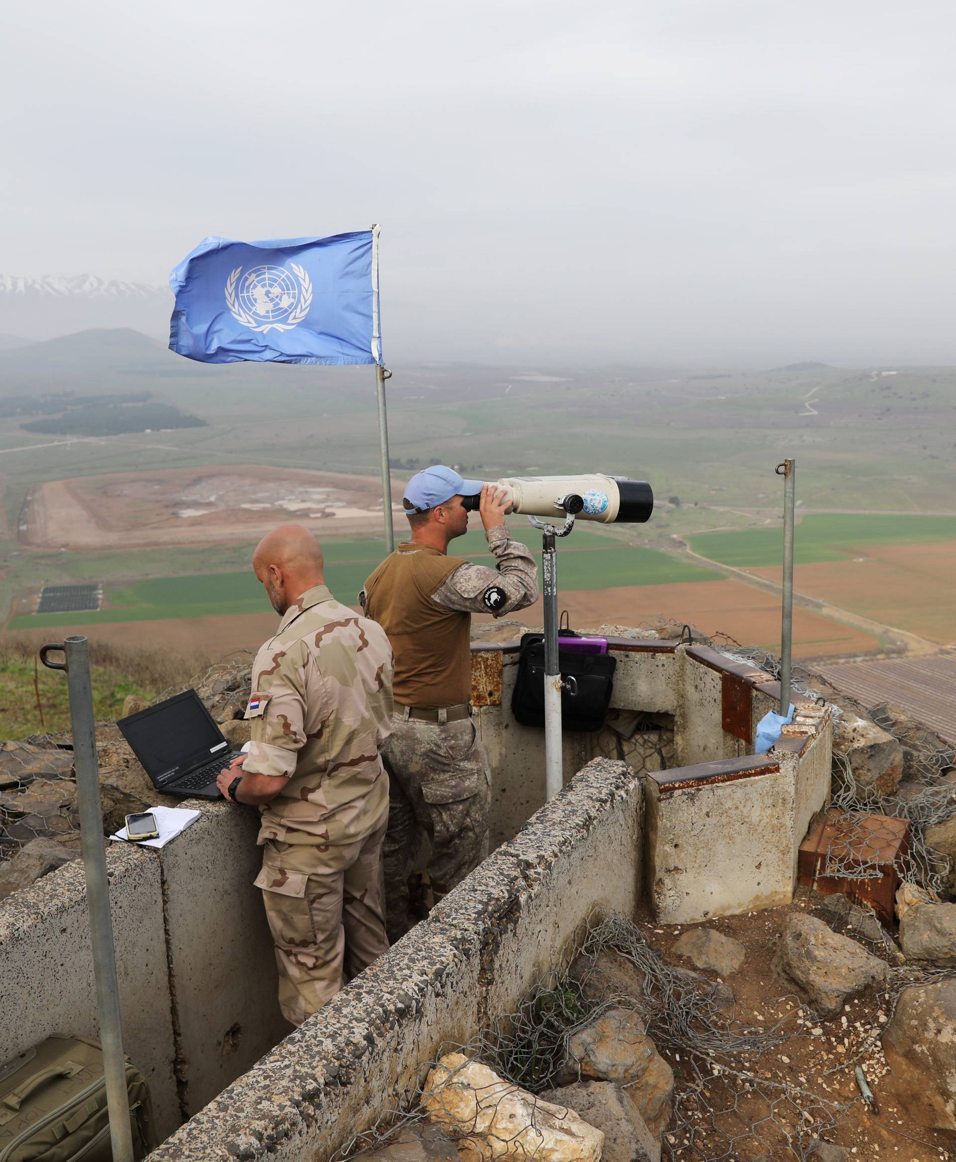 UN soldiers look out on a post at Mount Avital, in the Israeli-occupied Golan Heights near the Israeli Syrian border