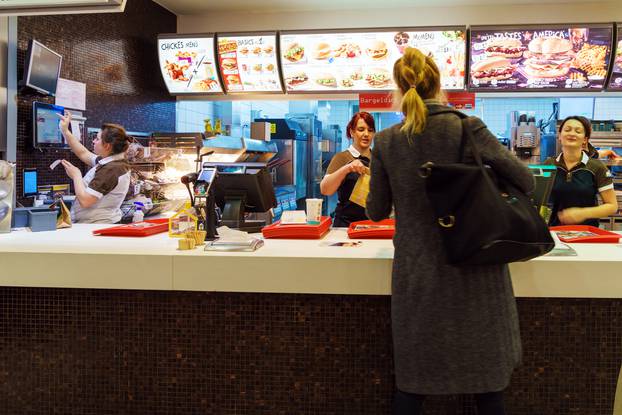 The girl receives an order in the interior of the McDonald