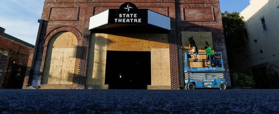 People put plywood up on the windows of a theatre before the arrival of Hurricane Florence in Greenville