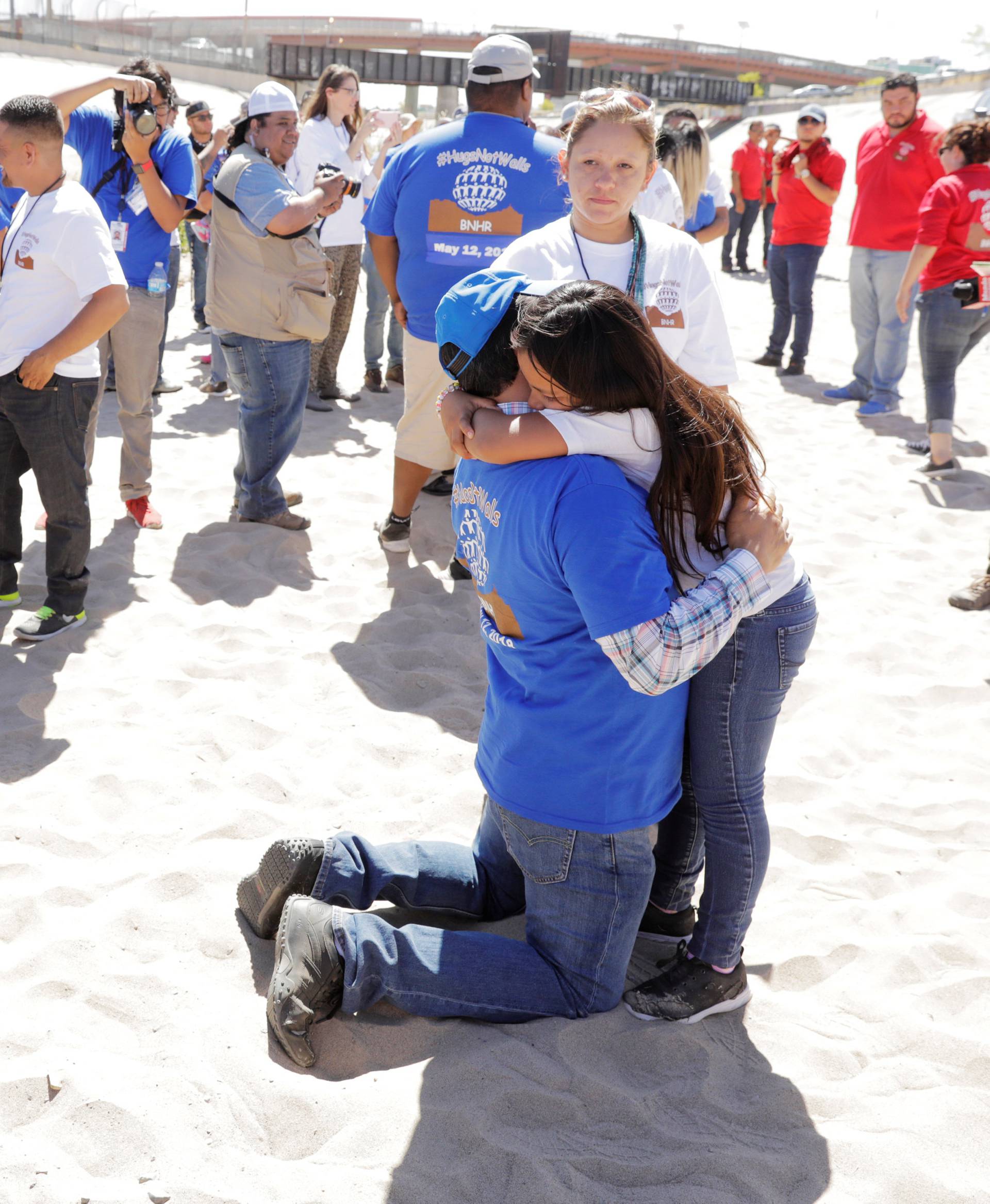 Family members from the United States (in blue) and Mexico (in white) greet each other for three minutes during the "Hugs not Walls" event in a riverbed of the Rio Grande on the border of Juarez, Mexico, and El Paso, Texas