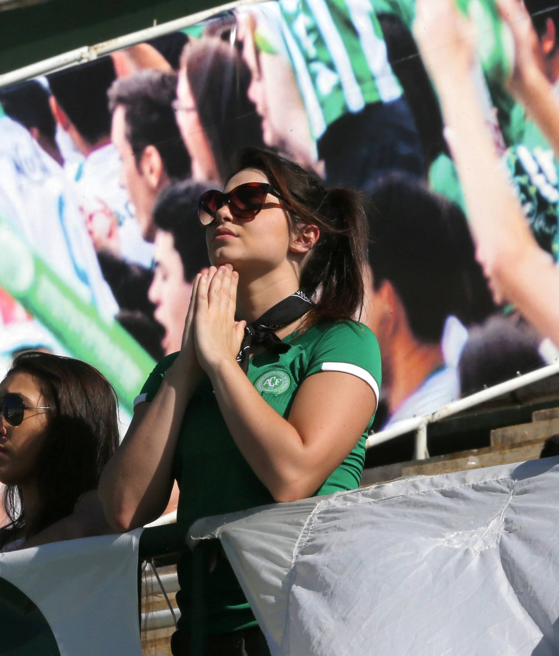 A fan of Chapecoense soccer team prays at the Arena Conda stadium in Chapeco