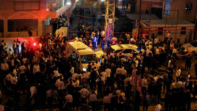 People gather at the scene of an attack in which people were killed by a gunman on a main street in Bnei Brak, near Tel Aviv