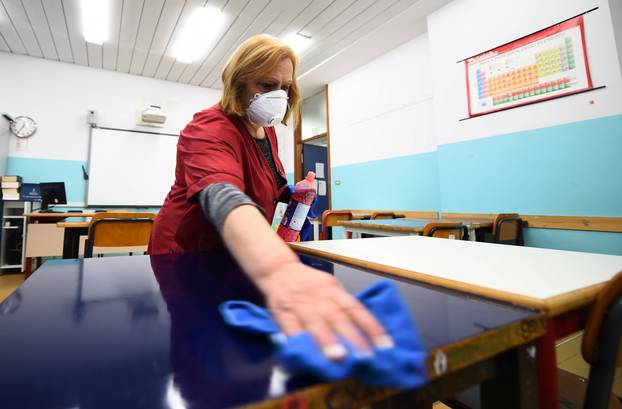 A cleaner sanitises a classroom at the Piero Gobetti high school in Turin