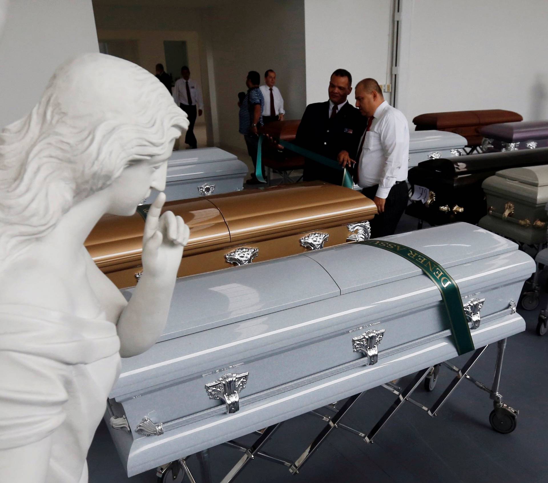 Funeral workers place ribbons with names on the coffins holding the remains of the victims who died in an accident of the plane that crashed into the Colombian jungle with Brazilian soccer team Chapecoense onboard, in Medellin