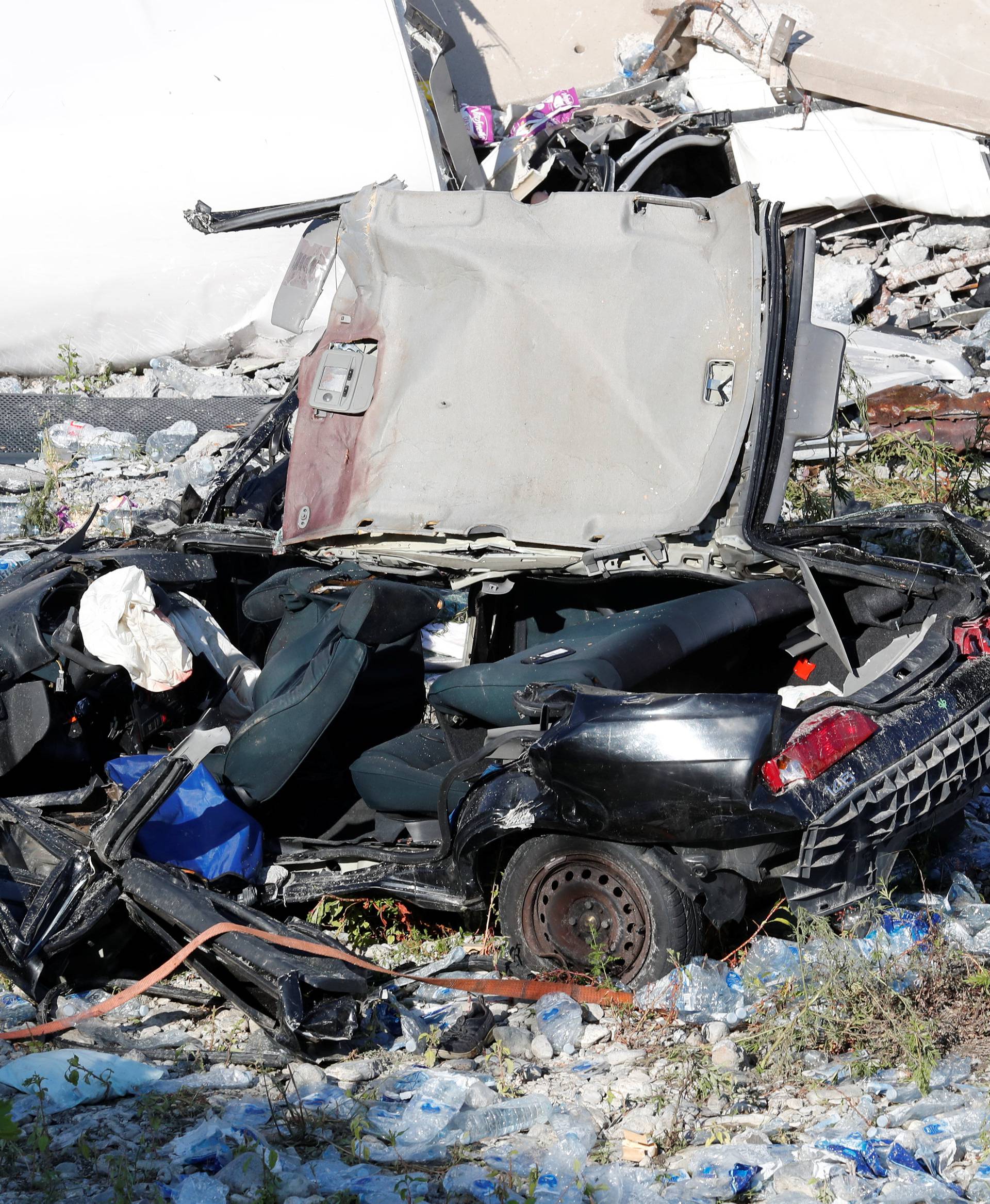 Crushed car is seen at the collapsed Morandi Bridge site in the port city of Genoa