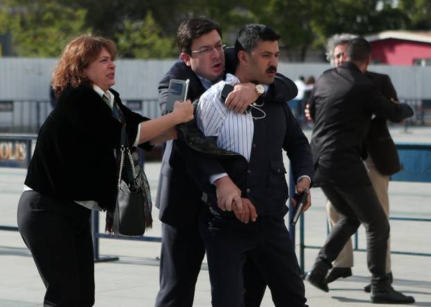 An assailant who attempted to shoot prominent Turkish journalist Can Dundar is caught by Dilek Dundar, wife of Can Dundar, and an unidentified man outside a courthouse in Istanbul