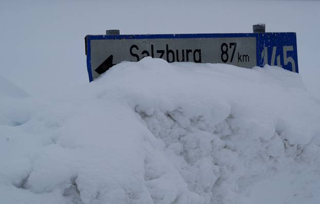 A street sign is covered in snow on an icy road in Knoppen