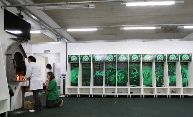 Employees of Chapecoense soccer team pray inside the team