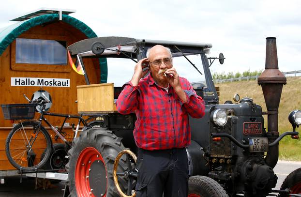 Soccer fan from Pforzheim, Germany, Hubert Wirth, 70, speaks on the phone while he rests by his tractor during his travel to attend the FIFA 2018 World Cup in Russia near the village of Yasen