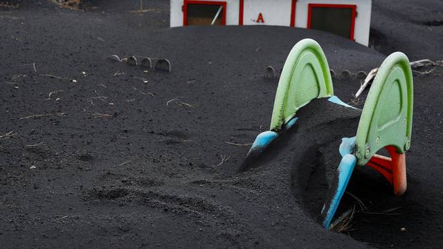A slide is seen buried in the ash from the Cumbre Vieja volcano in Las Manchas