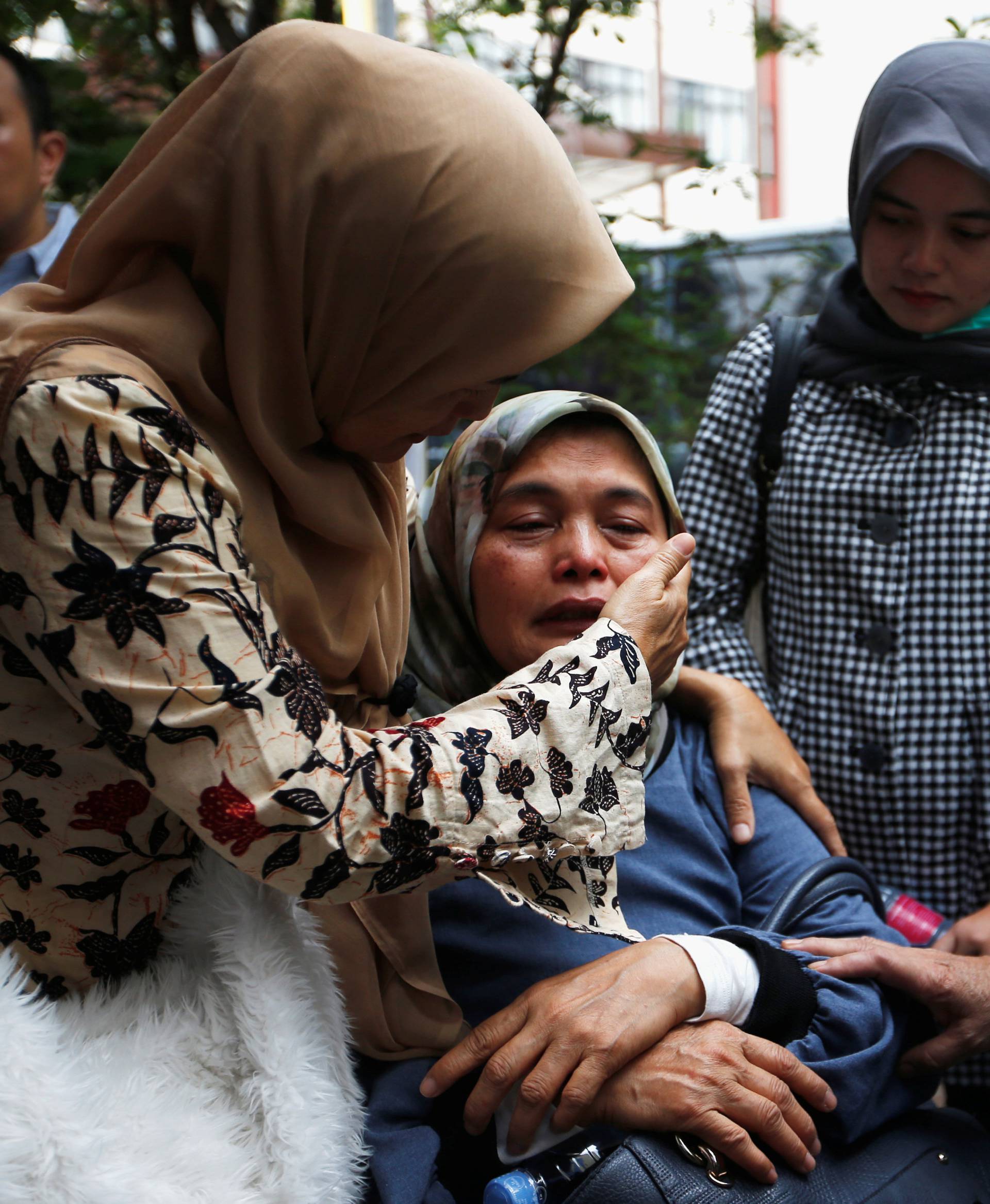 People, who are relatives of passengers on the crashed Lion Air flight JT610, cry at Bhayangkara R. Said Sukanto hospital in Jakarta
