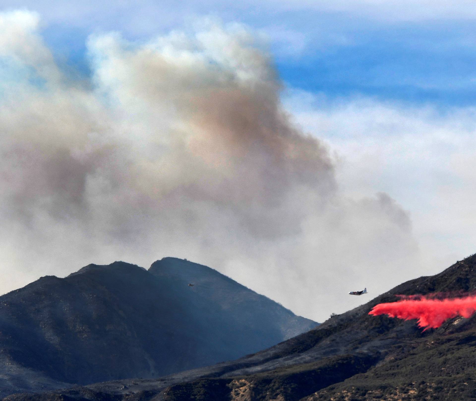 An aircraft drops fire retardant on the Thomas Fire, a wildfire in Fillmore, California