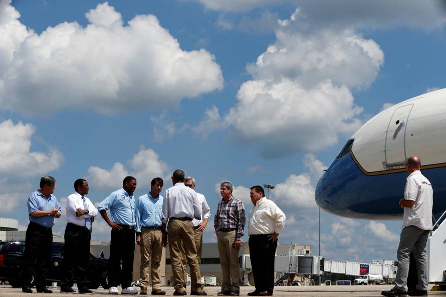U.S. President Barack Obama speaks with local and state officials as he arrives aboard Air Force One at Baton Rouge Metropolitan Airport in Baton Rouge