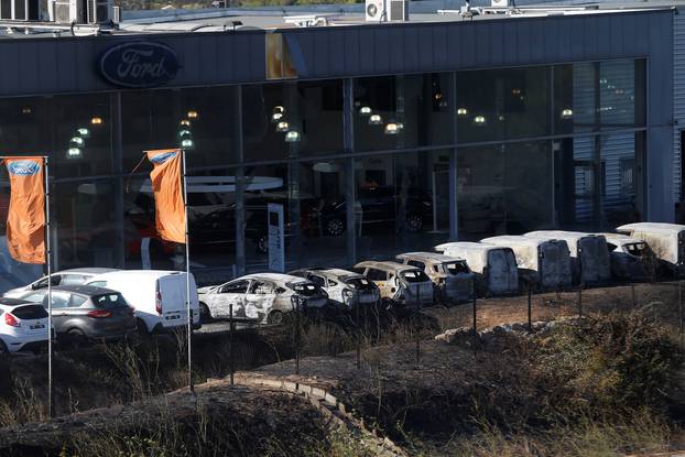 Destroyed cars are seen outside an automobile dealership in Vitrolles the day after fires, fanned by strong northern winds known as the mistral, ravaged more than 2,000 hectares of the dry, pine-planted hills north of Marseille