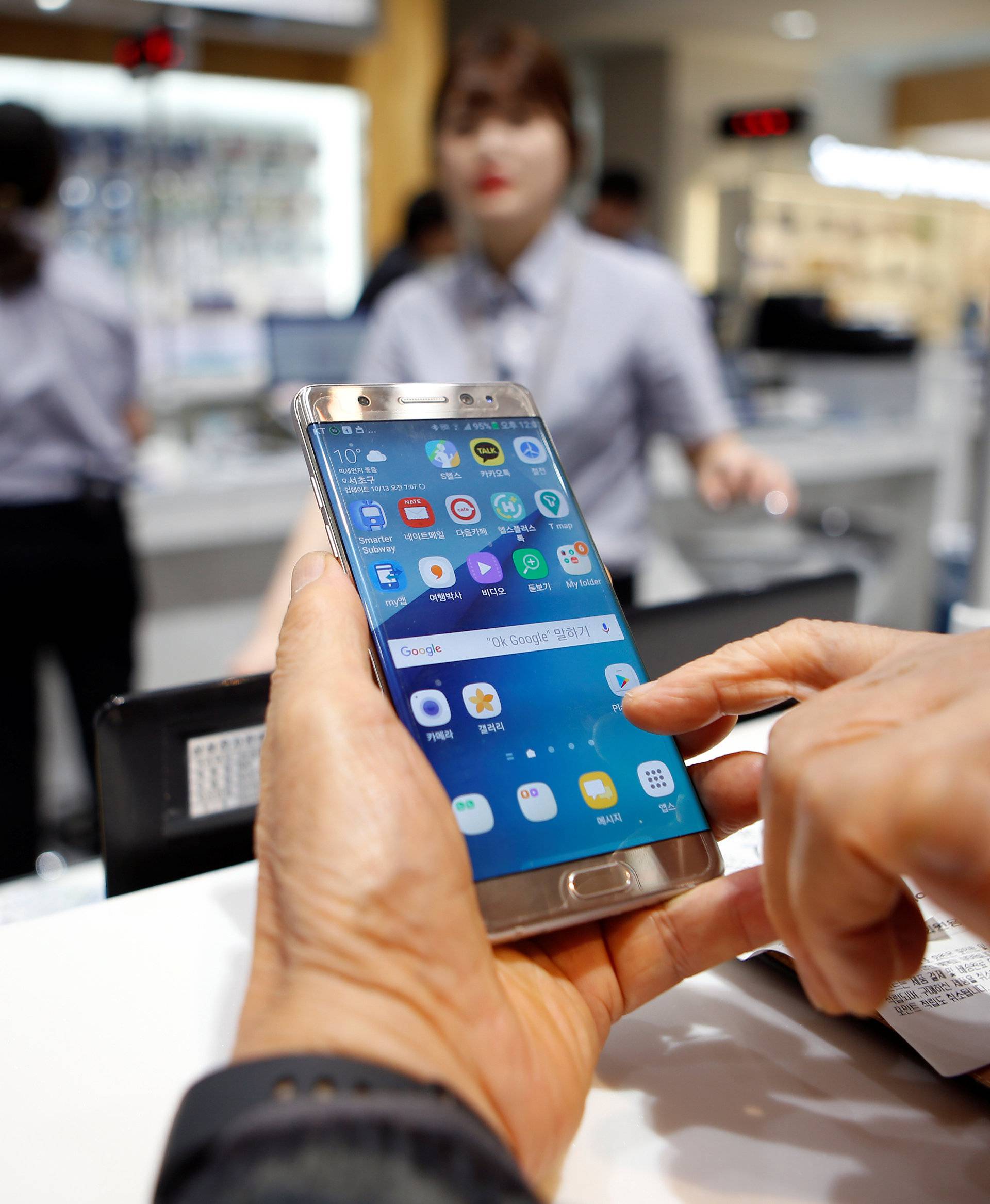 A customer uses his Samsung Electronics' Galaxy Note 7 as he waits for exchange at company's headquarters in Seoul