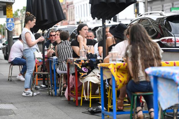 People are seen at a cafe after the state of Victoria saw COVID-19 case numbers drop in Melbourne