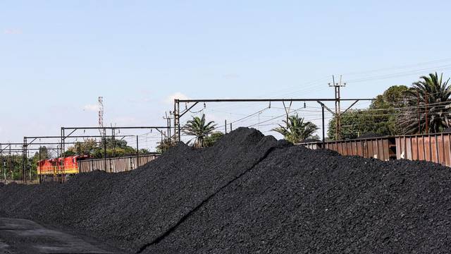 FILE PHOTO: A Transnet Freight Rail train is seen next to tons of coal