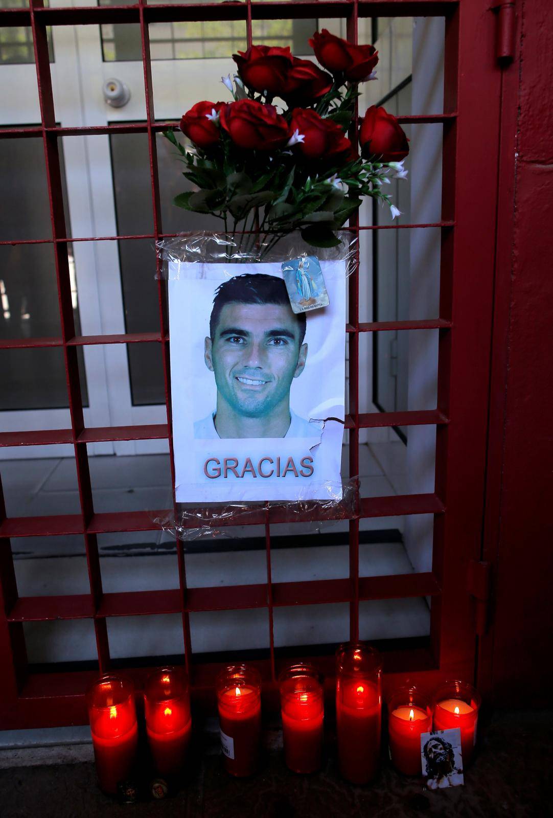 Flowers and lit candles are pictured next to a portrait  of Spanish footballer Reyes in Seville