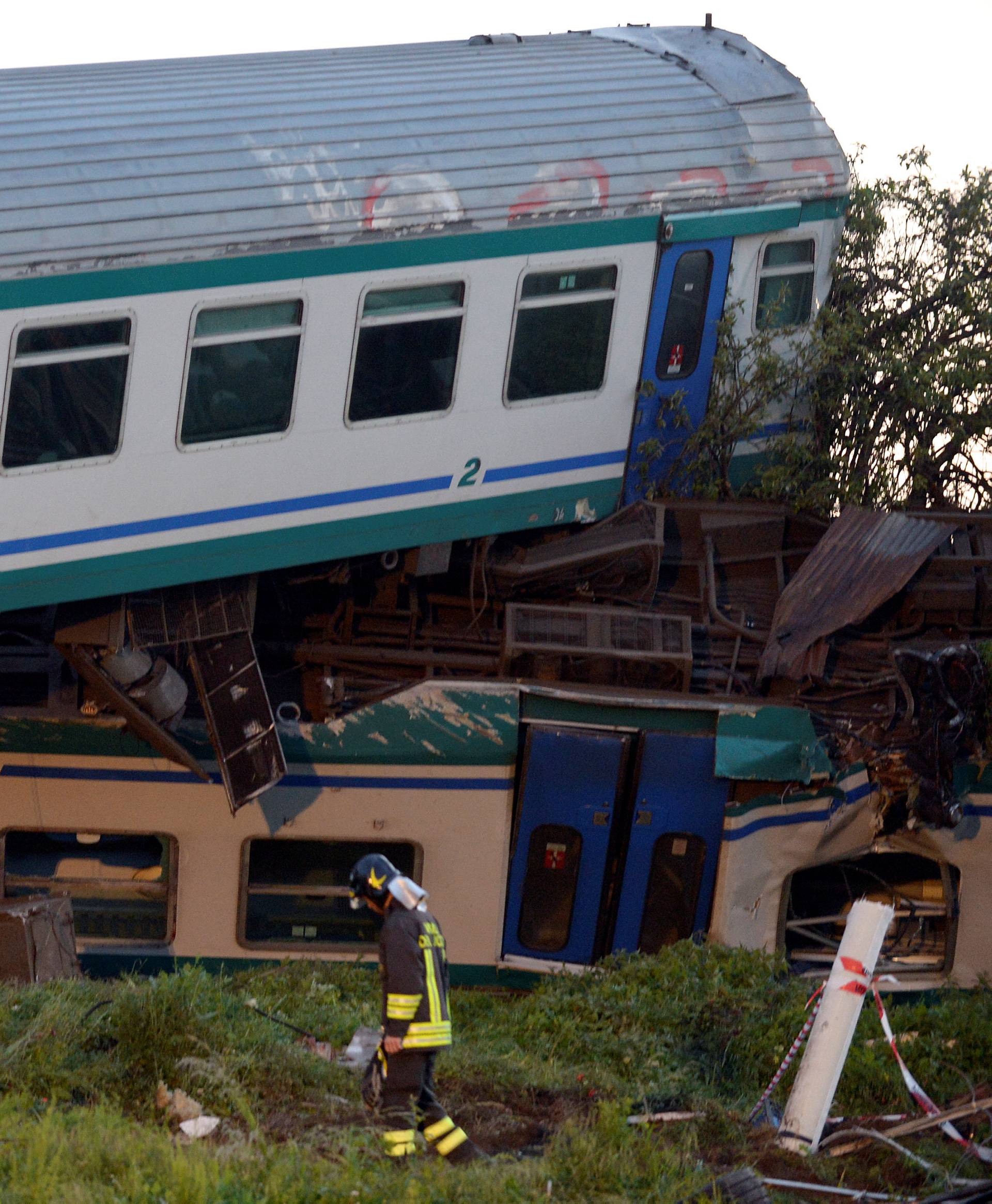 Fire fighter stands next to the twisted wreckage of a train that plowed into a truck last night in Caluso