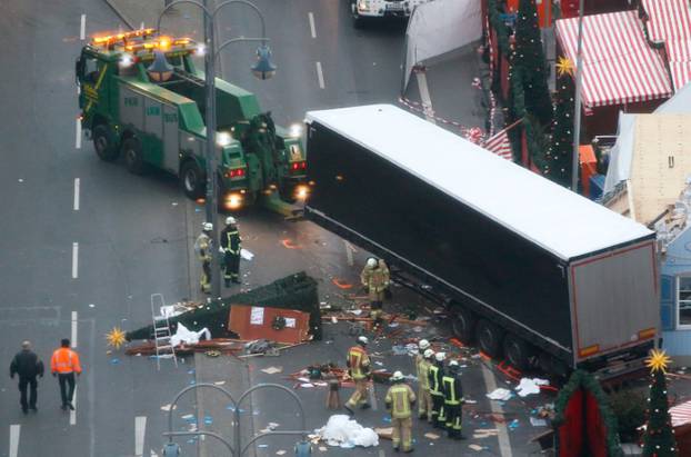 Rescue workers tow the truck which ploughed into a crowded Christmas market in the German capital last night in Berlin