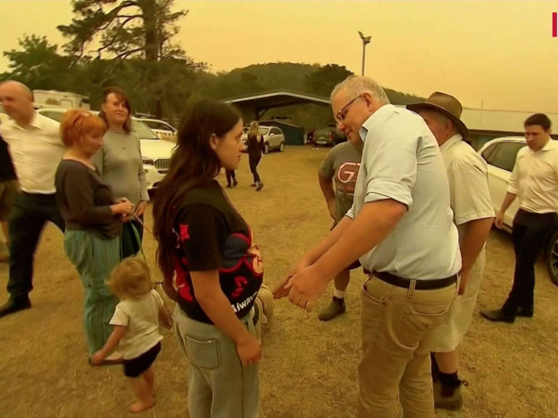 Australia's Prime Minister Scott Morrison attempts to shake a resident's hand during a visit to the bushfire-stricken town of Cobargo