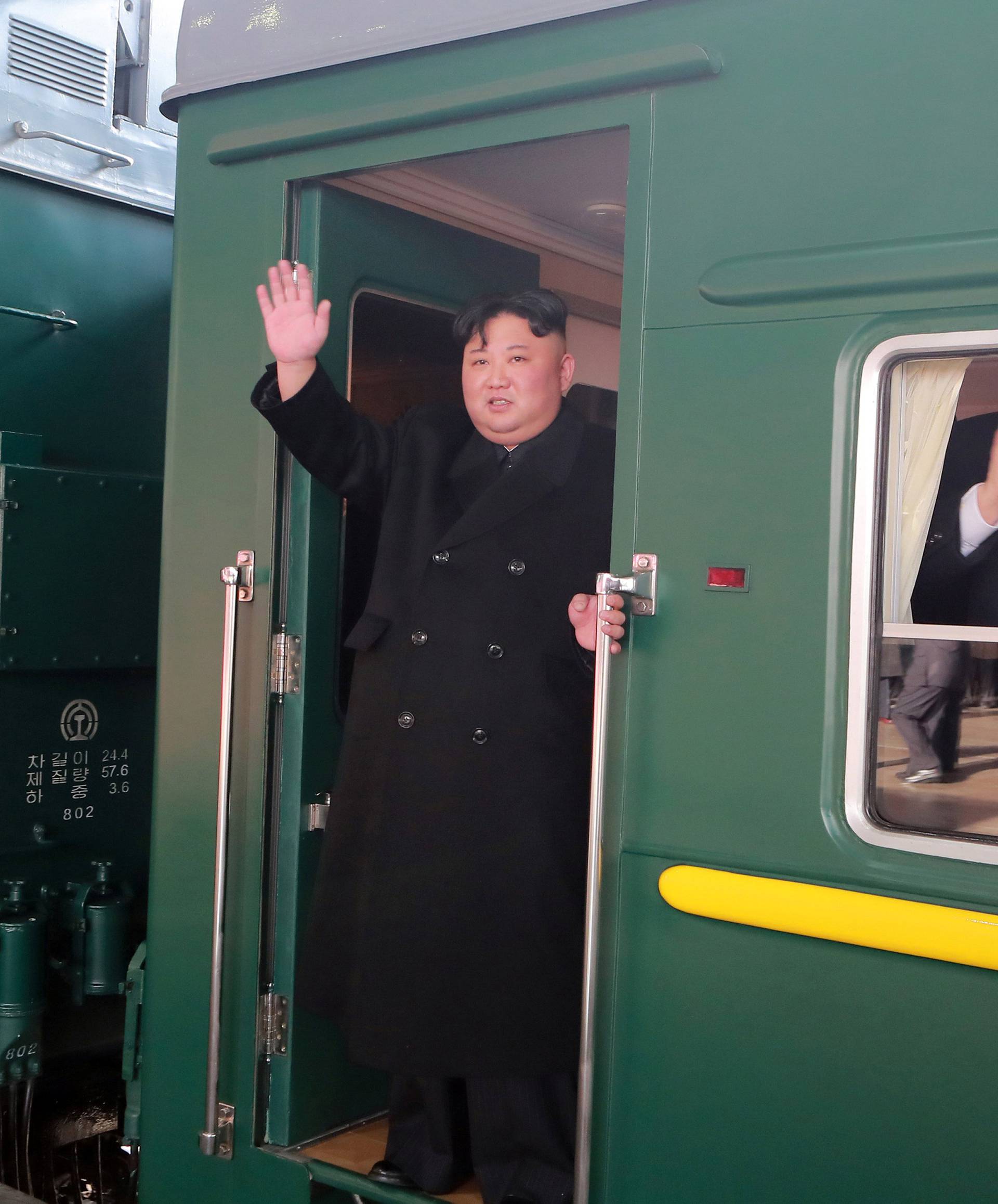 North Korean leader Kim Jong Un waves from a train as he departs for a summit in Hanoi