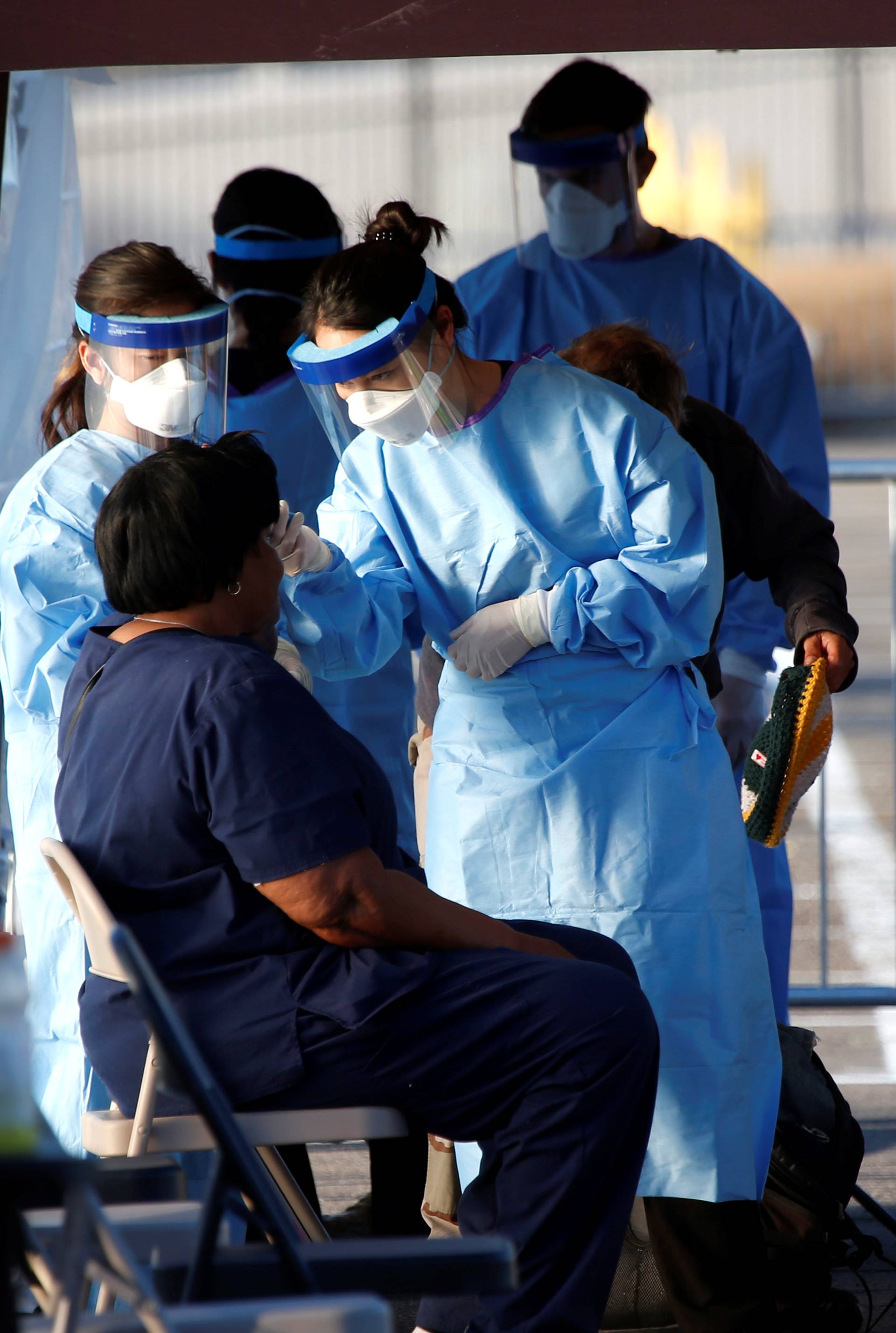 A medical student from Touro University Nevada takes the temperature of a person at a temporary parking lot with spaces marked for social distancing in Las Vegas