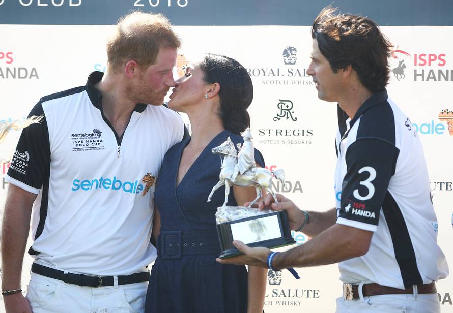 Britain's Prince Harry kisses his wife Meghan the Duchess of Sussex after a charity polo match in Windsor