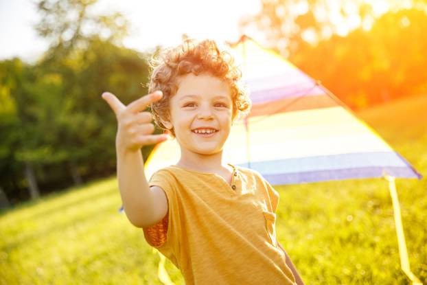 Cheerful boy showing rock sign