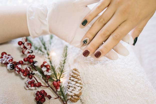 Girls hands being nail polished for Christmas season
