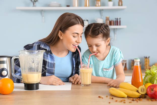 Mother,And,Little,Daughter,With,Healthy,Smoothie,In,Kitchen