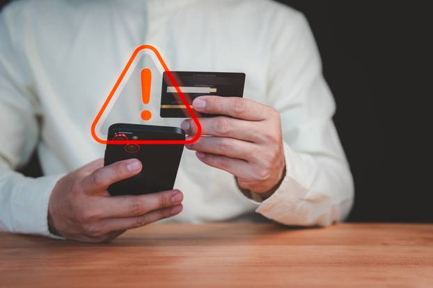 A,Person,Holding,A,Credit,Card,And,Smartphone,With,A