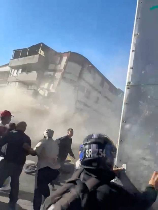 People watch as a building collapses during an earthquake in Pereira