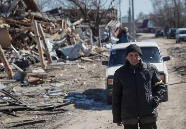 Local resident walks in a destroyed village on the front line in the east Kyiv region