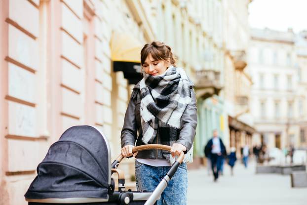 Young,Beautiful,Mother,Walking,With,Baby,Carriage,In,European,City
