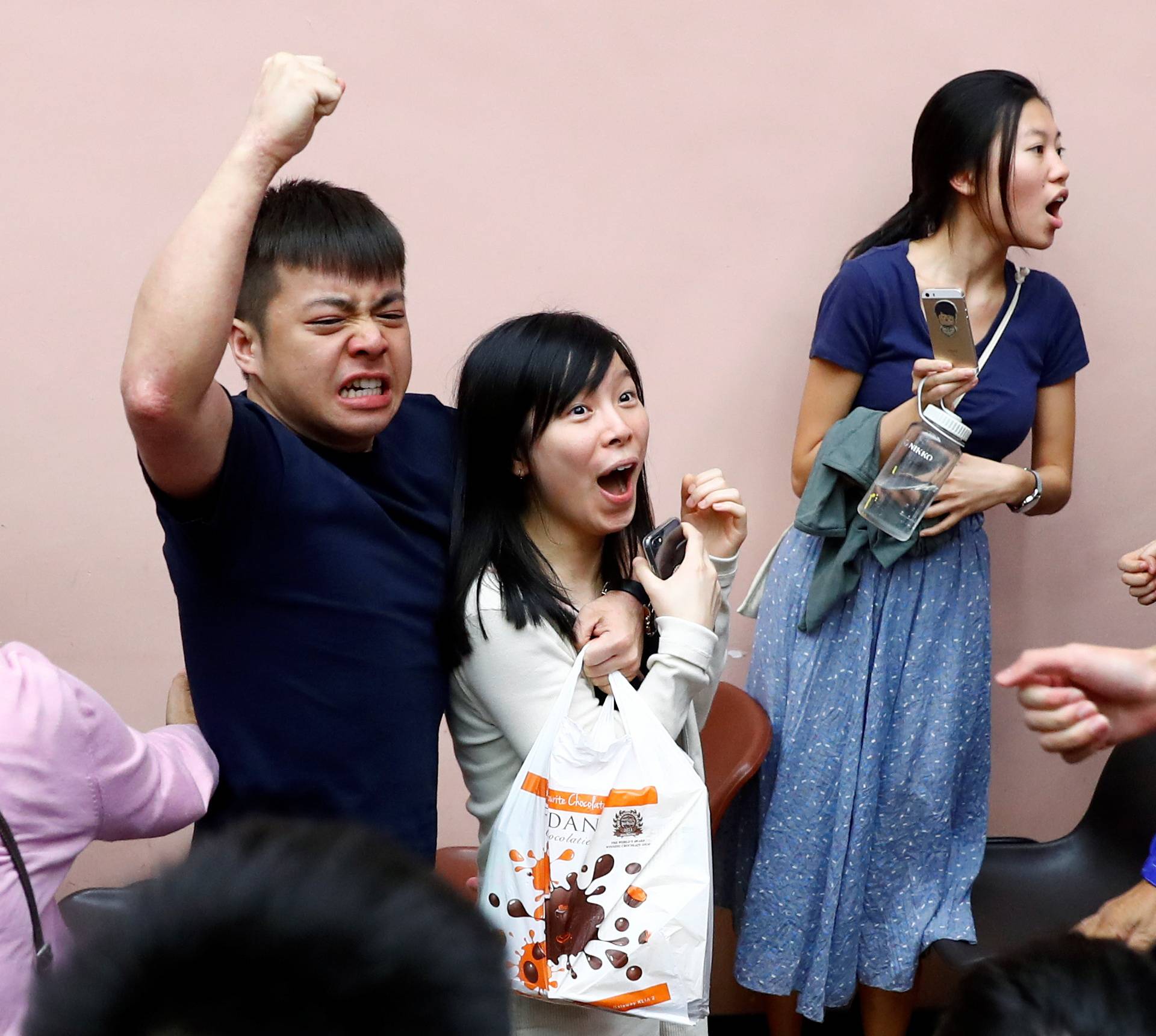 Supporters of local candidate Kelvin Lam celebrate at a polling station in the South Horizons West district in Hong Kong