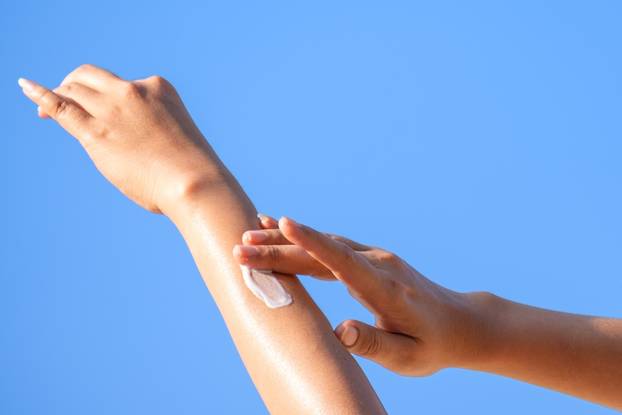 A,Woman,Is,Applying,Sunscreen,And,Skin,Care,To,Protect