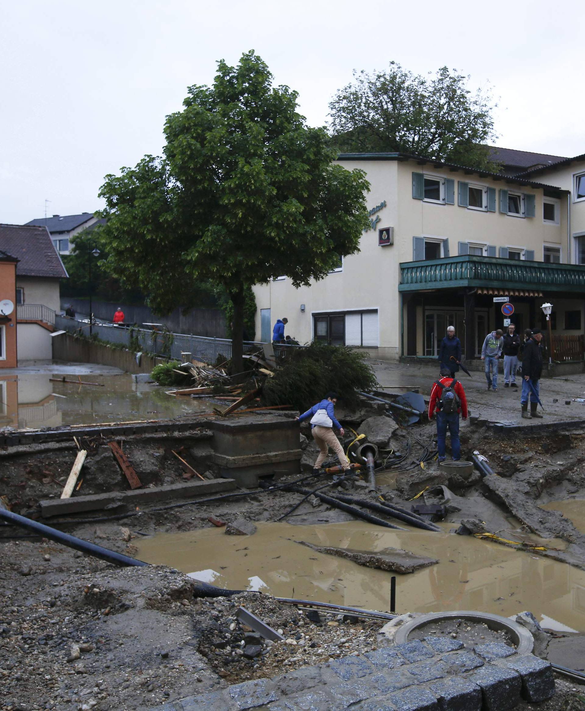 People walk in the street damaged by floods in the Bavarian village of Simbach am Inn