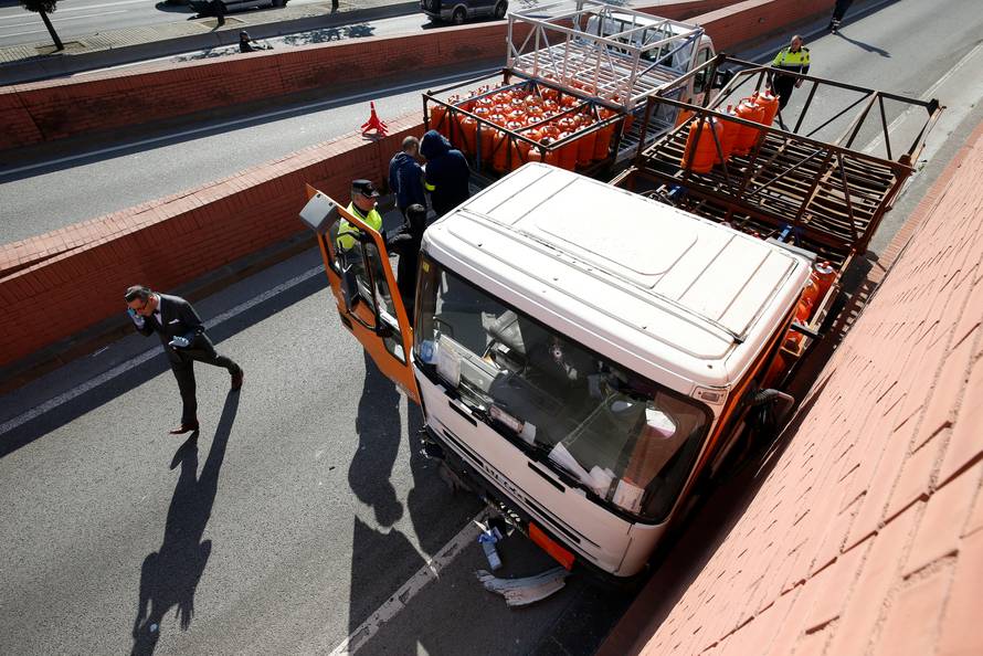 Police work at the scene of a gas cylinder delivery truck with bullet holes in its windscreen after police fired shots to stop the driver, whom they say had stolen the truck and was driving against traffic, in Barcelona, Spain