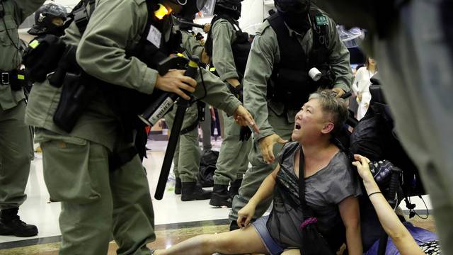 Riot police detain a woman during a protest at a shopping mall in Tai Po, Hong Kong