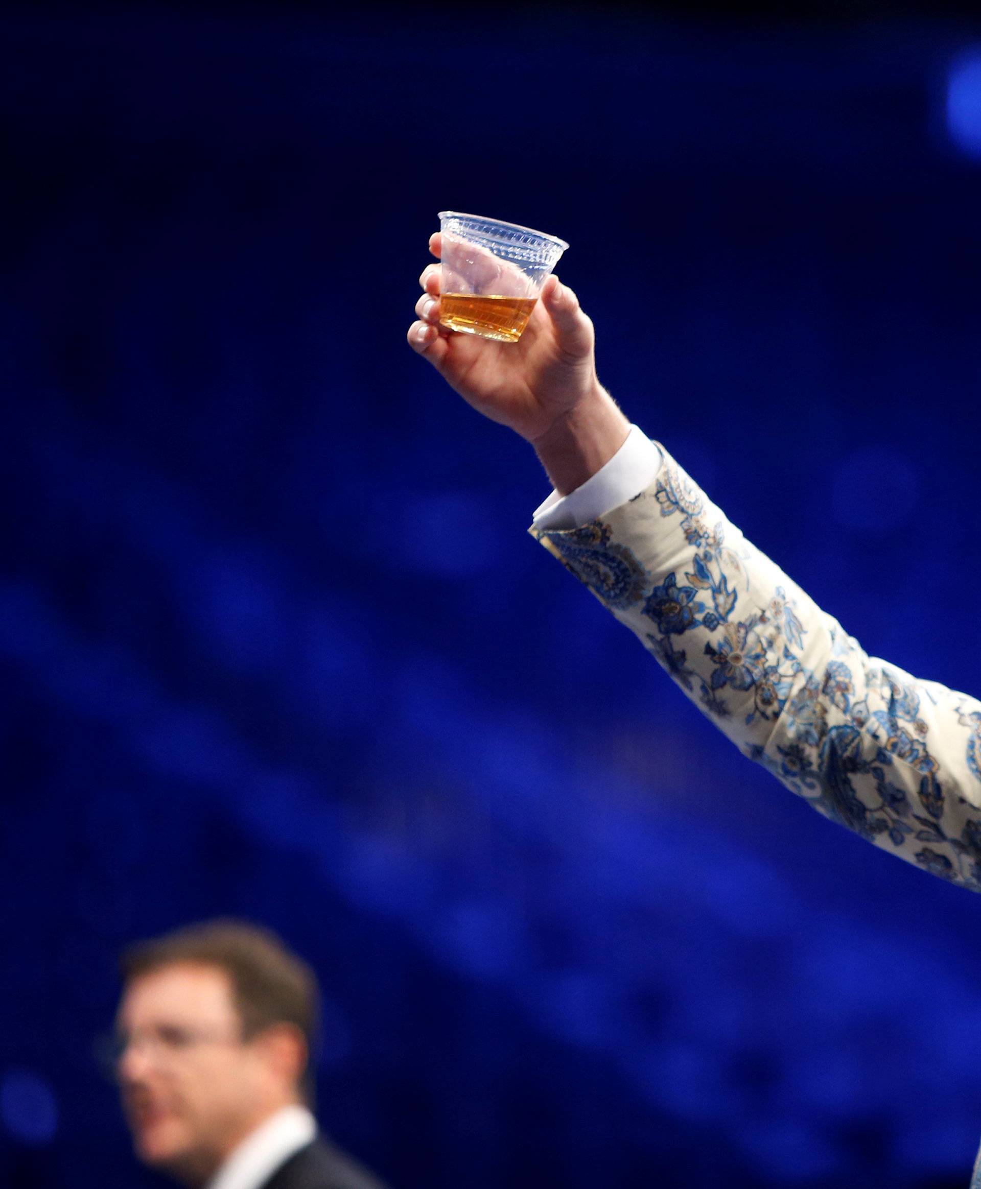 UFC lightweight champion Conor McGregor of Ireland raises a cup of Irish whiskey during post-fight news conference at T-Mobile Arena in Las Vegas