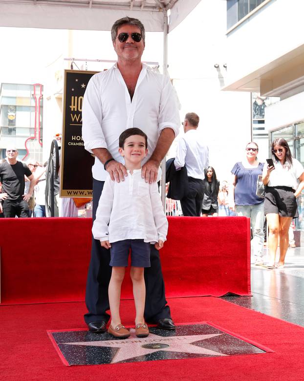 Television producer Cowell and his son Eric pose on his star on the Hollywood Walk of Fame in Los Angeles