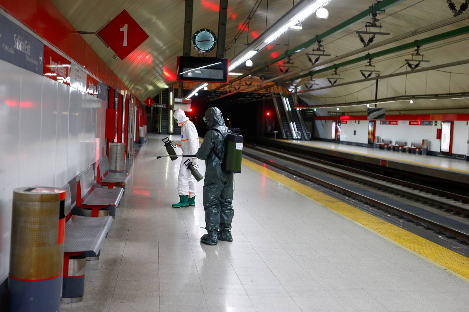 Military Emergency Unit members disinfect Nuevos Ministerios metro station during a partial lockdown as part of a 15-day state of emergency to combat the spread of coronavirus disease (COVID-19) in Madrid