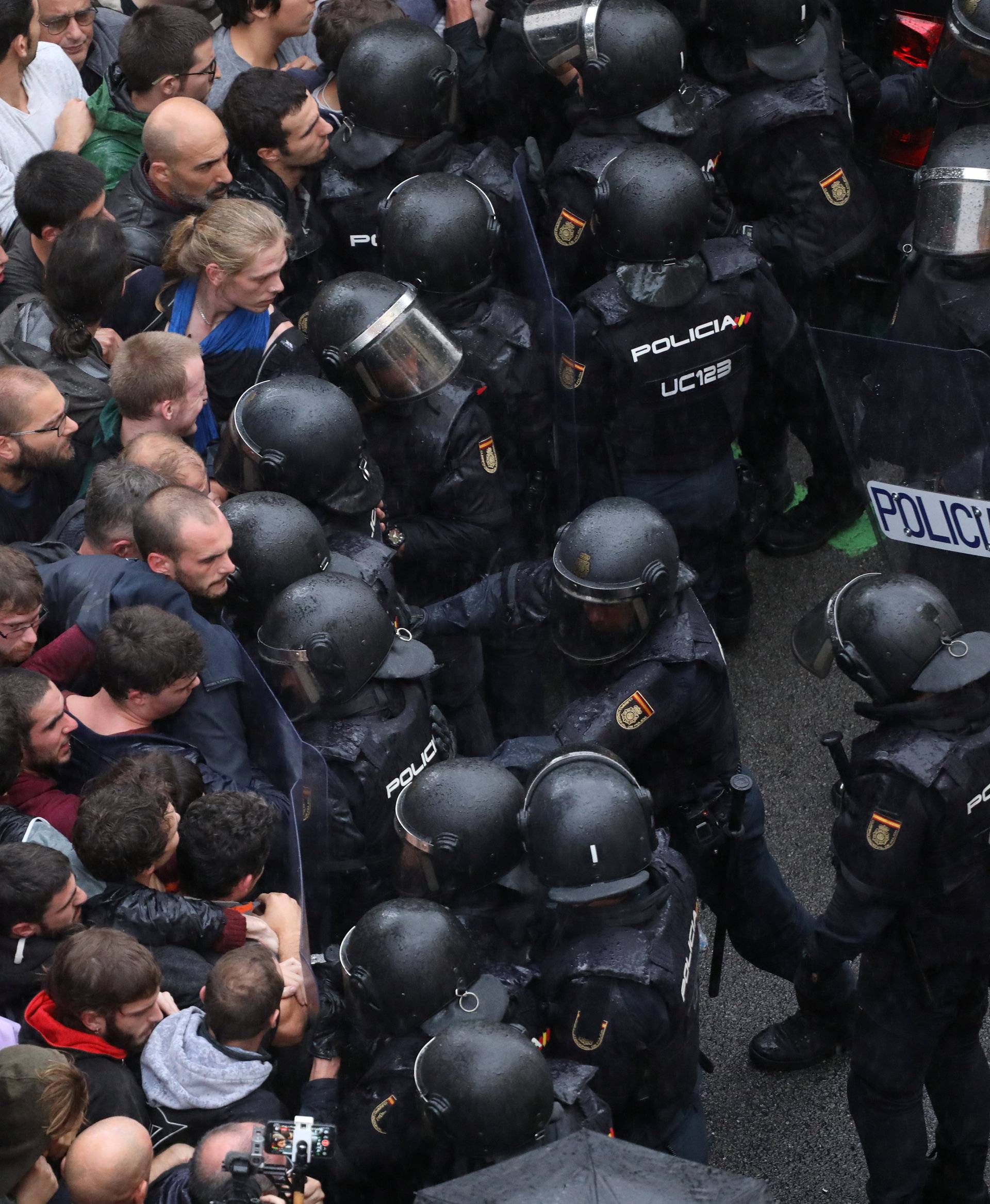 Riot police face off with demonstrators outside a polling station for the banned independence referendum in Barcelona
