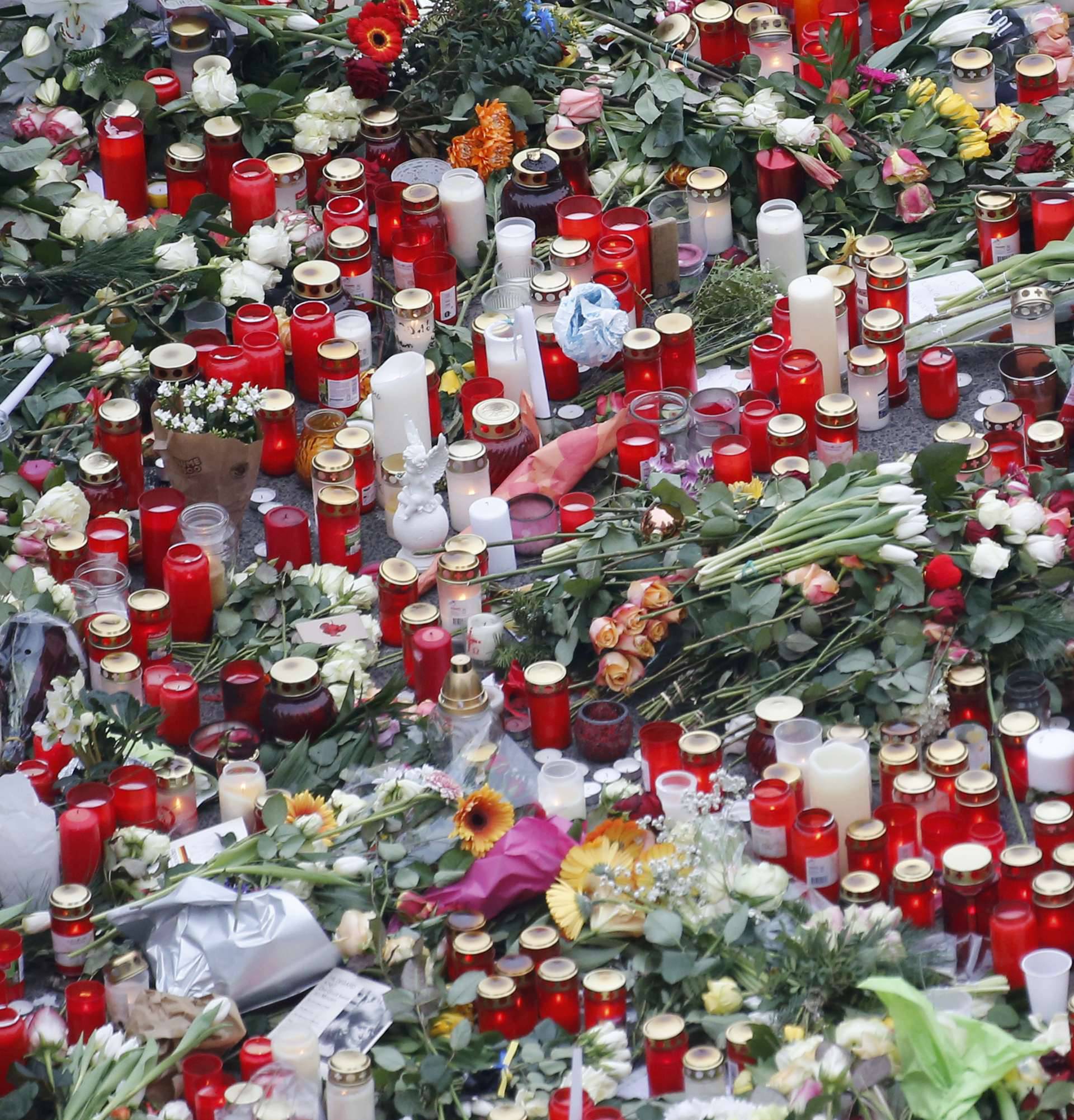 Flowers and candles are placed near the Christmas market in Berlin