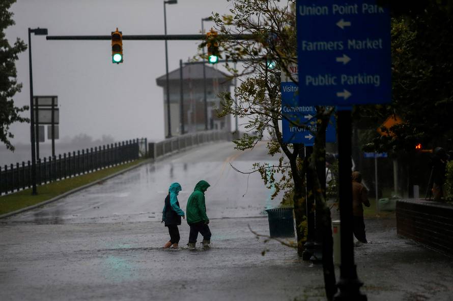 People walk on a local street as water from Neuse River starts flooding houses upon Hurricane Florence coming ashore in New Bern, North Carolina