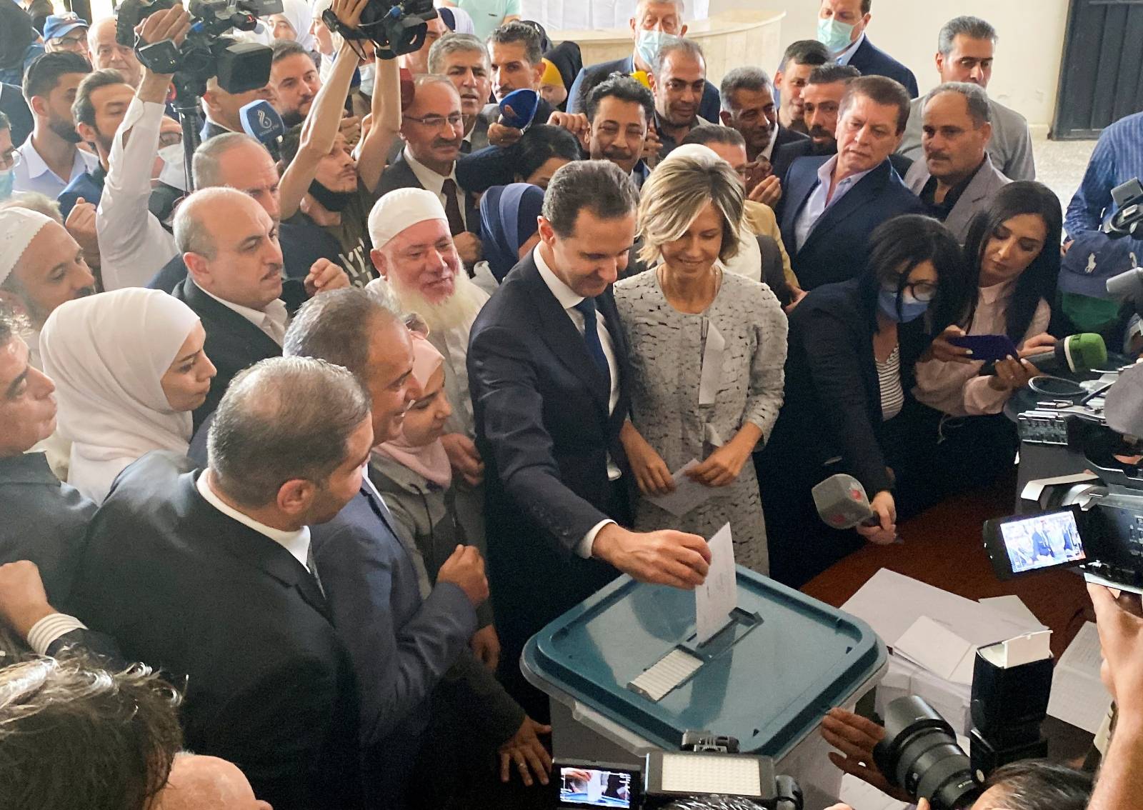 Syria's President Bashar al-Assad and his wife Asma cast their votes during the country's presidential elections at a polling station in Douma